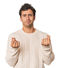 Young Hispanic man in studio showing that she has no money.