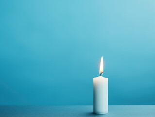 Sky Blue background with white thin wax candle with a small lit flame for funeral grief death dead sad emotion with copy space texture for display 