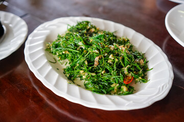 ChaKram leaves fried in oil resemble green leaves. Garlic is stir-fried with.