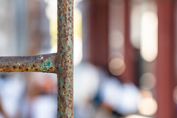 Close up shot of rusty metal pole and scaffolding on blurry construction work site background.