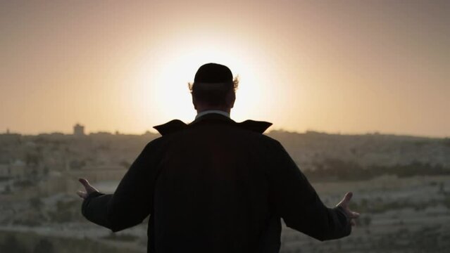 Jewish man standing in front of Jerusalem during sunset