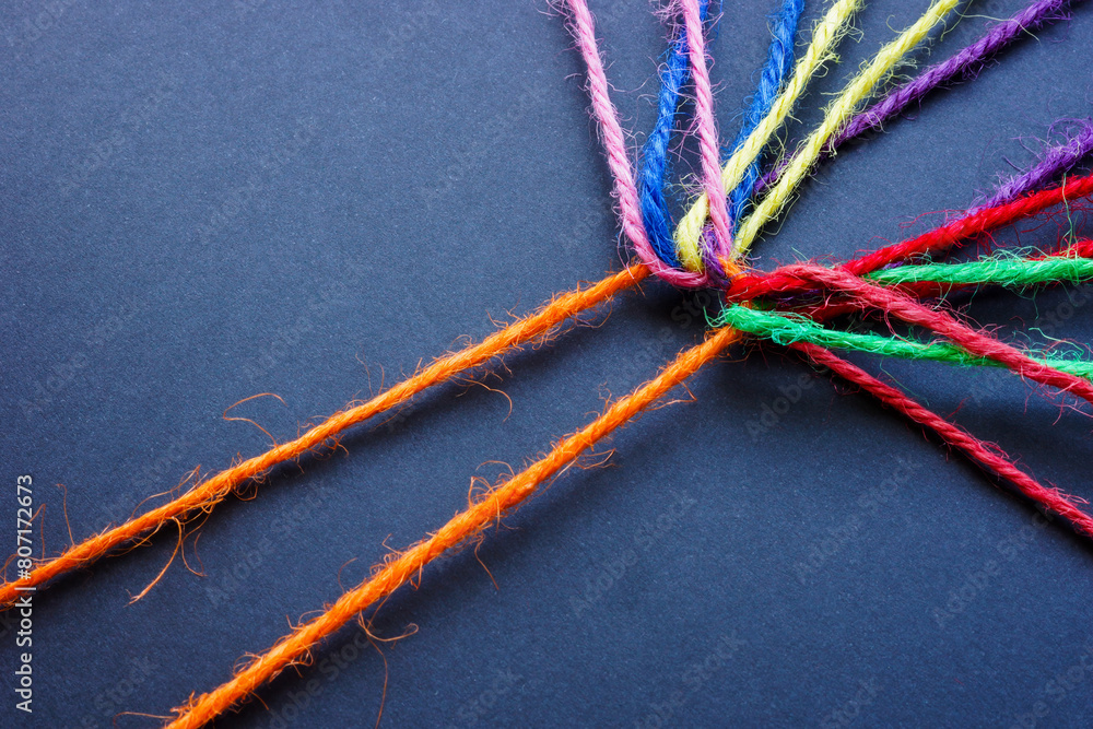 Wall mural orange thread connecting colored threads. teamwork and diversity.