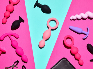 Sex toys background. Anal plugs and dildo over blue and pink backdrop