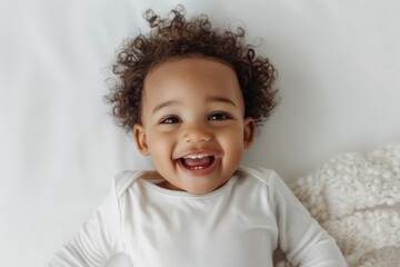 Cute and playful portrait of happy 1.5 years old child playing on white bright solid studio background, top view. Funny face. Baby Development. Child's emotions. Cheerful One year old kid having fun
