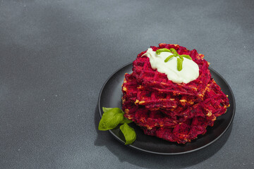 Homemade beetroot Belgian waffles with sauce. Gluten free vegan food with vegetables
