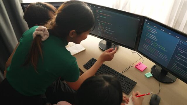 Slow motion back end software developer engineer for computer programming working together on debugging writing computing code, solving complex algorithms display on monitor in office. Burgeoning