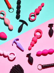 Sex toys background. Anal plugs and Dildo over pink backdrop - obrazy, fototapety, plakaty