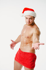 Handsome man with an athletic body wearing a Santa Claus costume. White background.