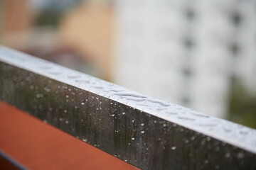 Raindrops on an iron handrail, wet railings, close-up