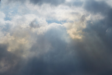 Sky with clouds through which heavenly light pours, sunlight passes through the clouds, light after the storm
