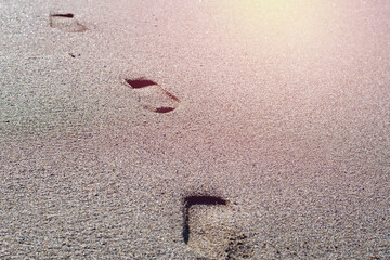 Footprints on sand seashore at summertime.Copy space, Bright sunlight