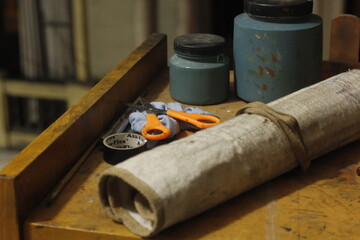 Peering through an old building's window reveals an artist's nook, where a table holds painting...