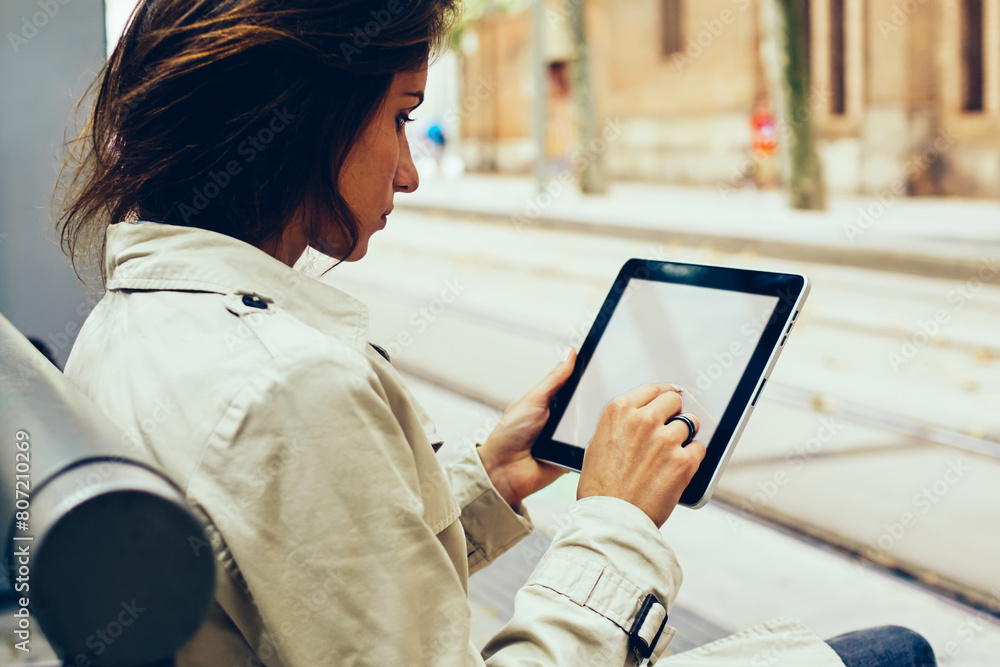 Poster young woman typing text on modern touch pad device with mock up area for your website content sittin