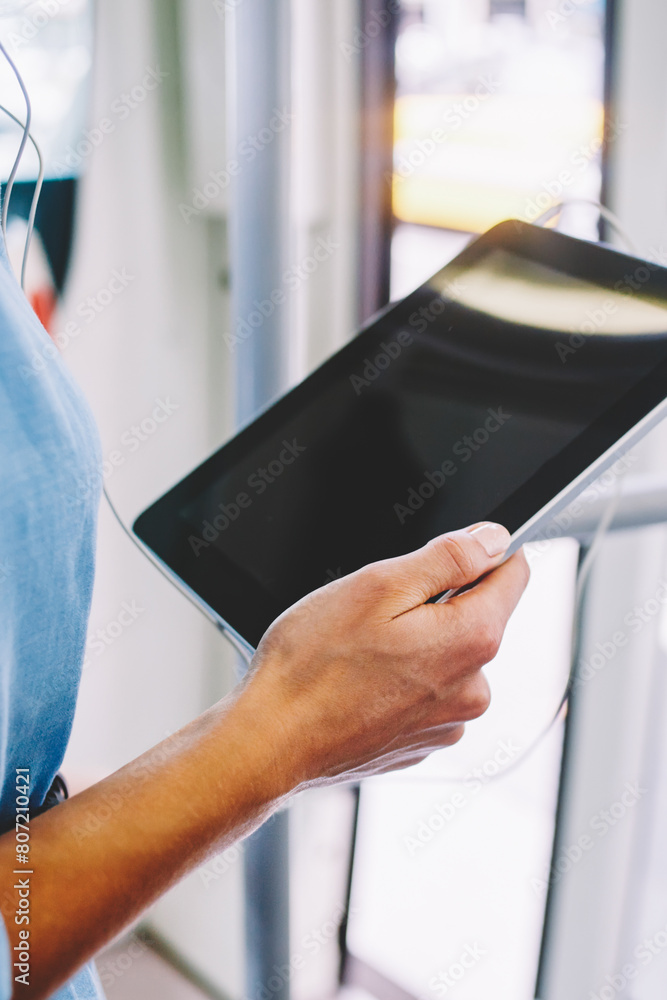 Poster cropped view of woman's hands holding digital tablet in hands during installing application via free