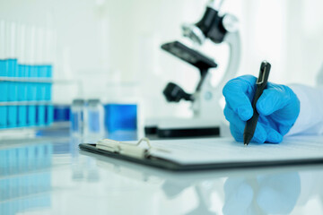 Medical or scientific researcher or man doctor looking at a test tube of clear solution in a laboratory