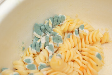 Pasta with mold, spoiled pasta close up, blue mold. ugly food, food waste recycling concept