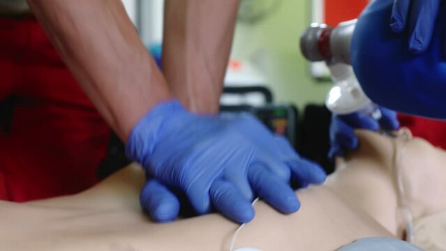 Hands of paramedic and doctor during resuscitation. Team of emergency medical service during CPR training on dummy. Themes rescue, urgency and health care. Real time in 4K resolution.