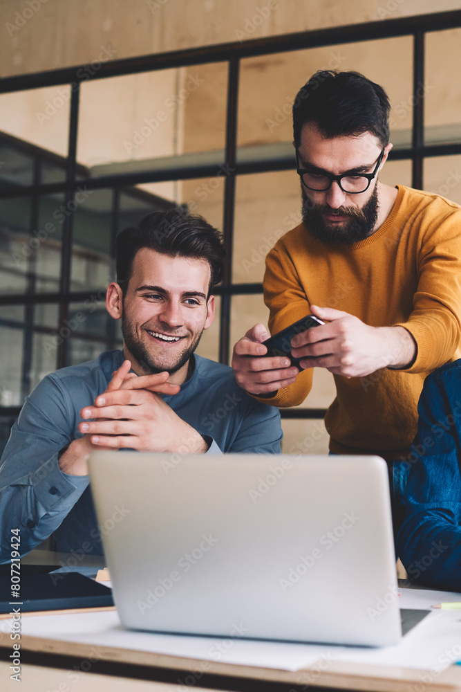 Aufkleber millennial hipster guys collaboration together in coworking space sitting at desktop with laptop whi