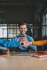 Unsociable hipster guy overuse mobile phone ignoring real communication while his male colleagues shaking hands during meeting, agreement and congratulation, problem of millennial internet addiction