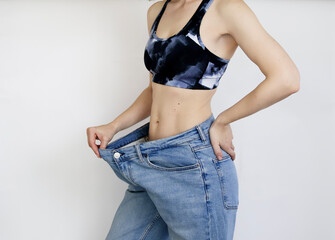 The girl lost weight doing exercise, her jeans became big on her.