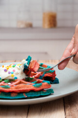 desayuno, close-up waffles deliciosos de colores para desayunar en la cocina, cortando waffle