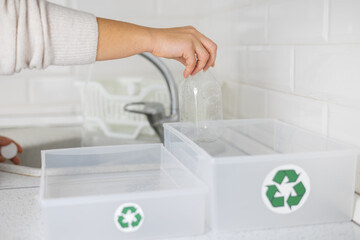 A woman washes plastic bottles in the kitchen to send them for recycling. Zero waste, eco friends....