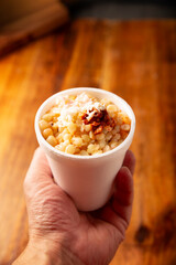 Esquites. Corn kernels cooked and served with mayo, sour cream, lemon and chili powder, very...