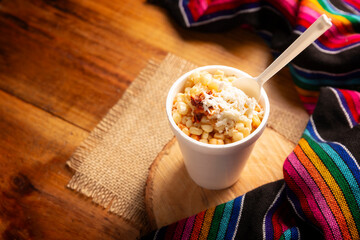 Esquites. Corn kernels cooked and served with mayo, sour cream, lemon and chili powder, very...