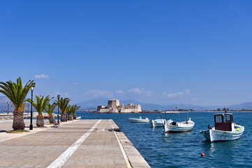 Small fishing boats and Bourtzi fortress in Nafplio, Peloponnese, Greece - Powered by Adobe