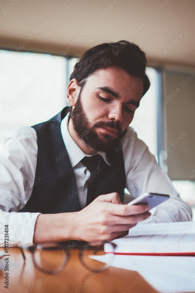 Poster bearded male blogger reading message from follover via telephone while creating new profile publicat