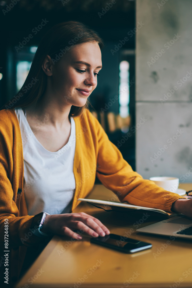 Poster positive millennial hipster girl searching information for e learning while sitting at cafeteria wit