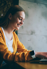 Fototapeta premium Happy woman laughing from messaging with friend in social network browsing wireless internet on laptop device, cheerful hipster girl making positive conversation with followers typing text on netbook