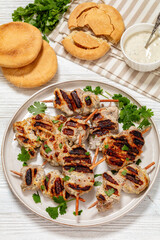 grilled mini pork skewers on a plate, top view