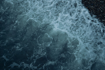 water flowing, waves on a stone beach