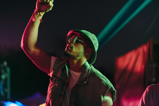 Young man dancing to the rhythms of a summer music concert