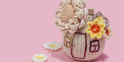 Handmade home spring decor concept. Creative crocheting, house figurine, traditional flowers