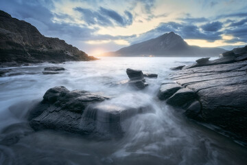 Sonabia beach at sunrise with the Sonabia beach at sunrise with the water between the rocks in the foreground