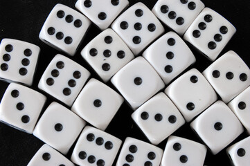 Top view of a group of dice in black background. Gambling addiction concept, rolled the die. White dice with different numbers for probability. Playing dice games for fun entertainment.