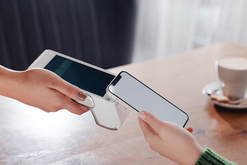 Payment by NFC phone. A woman pays contactlessly using a phone with NFC technology. Wireless money...