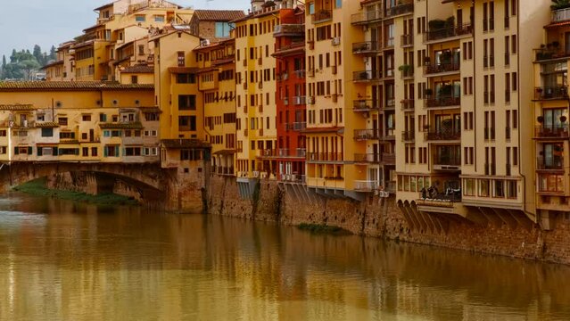 Panoramic view of Ponte Vecchio in Florence, opened in 1345, spanning the Arno River featuring medieval market stalls