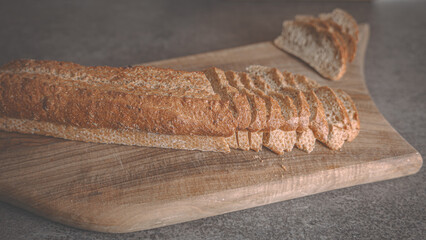 Baguette of sliced ​​buckwheat bread on a wooden cutting board. Closeup