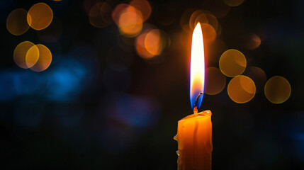 A single candle burns brightly against a dark bokeh