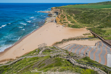 Walkway on a hill in aerial view with sand and bridge over river at Ribeira D'Ilhas beach, Ericeira - Mafra PORTUGAL