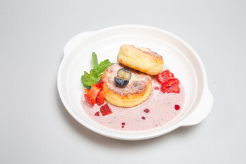 Freshly baked cottage cheese pancakes with berries on a plate