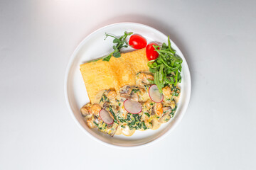 Top view Savory crepe with creamy mushroom sauce and fresh greens on a white plate