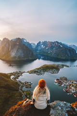 Woman traveling in Norway hiking on Reinebringen mountain, girl enjoying sunset Lofoten islands...