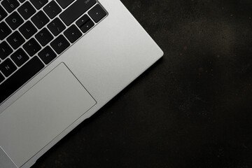 Top view of laptop on black background. Flat lay, top view office table desk.