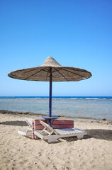 Beautiful sandy beach with sun loungers and umbrella, Marsa Alam region, Egypt.