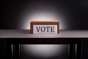 Voting box on desk on gray with dramatic lighting