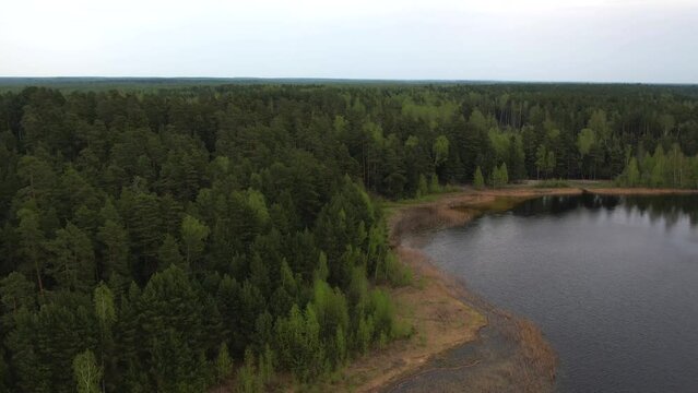 Bird's eye view of the lake in the forest. It's cloudy outside. Hiking trip
